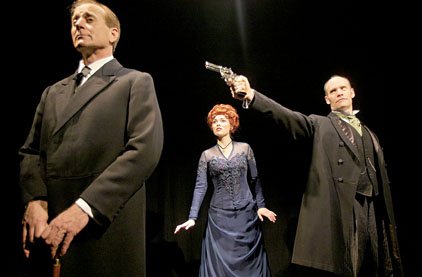 sherlock-holmes-played-by-joseph-graves-turns-his-back-on-his-arch-enemy-moriarty-mark-edward-waterman-while-holmes-girlfriend-irene-adler-heidi-marie-ferren-looks-on