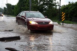 a-car-plows-through-floodwater-on-rebsamen-road-and-tree-tops-lane-saturday-night-in-little-rock