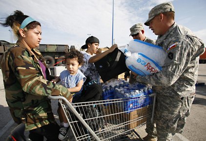 tabitha-romero-left-her-son-gavin-romero-2-and-dalaila-vasquez-get-water-ice-and-military-rations-at-a-fema-aid-distribution-site-for-relief-for-hurricane-ike-victims-in-galveston-texas-monday