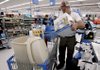Keith Mastin of Rogers loads items he bought Thursday at the Wal-Mart Supercenter in central Rogers. Wal-Mart reported that sales were up 5 percent in April at stores open at least a year.