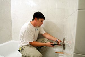 installer-lee-reece-with-the-company-the-better-bath-finishes-off-a-bathroom-remodel-by-installing-a-shower-temperature-control-in-the-bathroom-of-an-arkadelphia-home