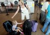 Ashlyn Weaver and her daughter Morghan, 3, of Morgantown, W.Va., wait to check their bags at Little Rock National Airport on Tuesday.