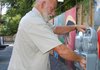  John Butler, a city worker, installs a parking meter Wednesday in front of The Artery, an outdoor art exhibit in Eureka Springs.