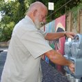  John Butler, a city worker, installs a parking meter Wednesday in front of The Artery, an outdoor a...