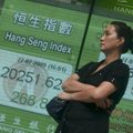 Pedestrians pass a stock board displaying the closing figure of the Hang Seng Index in Hong Kong on ...