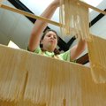 Brooke Pinalto, 12, places homemade noodles on drying racks Thursday while Tontitown residents make ...