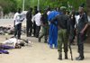Police stand alongside bodies of dead Islamic militants, in the street in front of police headquarters in Maidugiri, Nigeria, Wednesday.