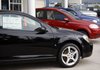 A 2009 Pontiac G5 coupe (foreground) sits on a lot at a General Motors dealership in Englewood, Colo., earlier this year. Vehicle orders fell by 8.7 percent in May and by 1 percent in June. 
