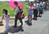 Guadalupe Rios, 5, of Rogers, left, and Maria Gonzalez waited in line Monday to receive free backpacks and school supplies at the Samaritan Community Center in Rogers. The center teamed up with the United Way to give away the backpacks and offer physicals, dental exams and back-to-school haircuts to local children in need. 