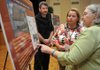 Joe Sobleskie of New York, national traffic and revenue program manager for Jacobs Engineering Group Inc.; and Virginia Porta of Little Rock, planning engineer for the Arkansas Highway and Transportation Department, explained the design of the proposed Bella Vista tolls to Cathy Luck of Bella Vista on Wednesday during a public-involvement meeting to discuss the proposed implementation of a toll facility for the Bella Vista bypass. 