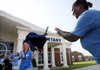 Tina Sexton (right) tosses a backpack to Clare Mathis while delivering donated items Thursday to Bayyari Elementary School in Springdale for the annual Jones Center Backpack Day.