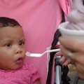 Azharia Douglas, 11 months, gets a taste of grape ice cream from her mother, Mindy Craig, on Thursda...