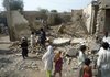 In this photo taken Tuesday, Aug. 4, 2009, Pakistani villagers look at a destroyed house belonging to supporters of Pakistani Taliban leader Baitullah Mehsud. Foreign Minister Shah Mahmood Qureshi said intelligence showed Mehsud had been killed Wednesday at his father-in-law's house in Pakistan's lawless tribal area.