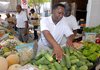 Abraham Carpenter, owner of Carpenter's Produce adds more cucumbers to his table in the Little Rock Farmer's Market. Carpenter's Produce is among a handful of state producers who sell locally grown produce to Wal-Mart Stores Inc. The Bentonville retailer continues the locally grown campaign it launched in 2006.