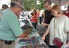 Norbert Ranalli, left, with Ranalli Farms helped Dianna Carpenter and Don Brown choose a carton of grapes Thursday during the 111th Tontitown Grape Festival at St. Joseph Catholic Church in Tontitown.