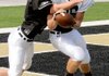 Senior defensive back Christian Larimer, left, tried to strip a pass from senior receiver Sheldon Vanderpool during Bentonville's football practice Friday at Tiger Stadium.