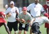 Arkansas coach Bobby Petrino takes a few snaps at quarterback while spelling freshman Brandon Mitchell during practice Friday at the UA practice field.