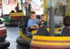 Kolton Dickens, 10, and his brother, Evan Dickens, 6, of Van Buren laugh while riding the bumper cars Saturday at the Tontitown Grape Festival. 