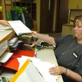 Bridgette Secrist, Washington County deputy circuit clerk, hands papers to a resident after filing p...