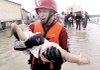 A rescuer carries a baby out of floodwaters Sunday after a typhoon hit Pintung county, southern Taiwan.