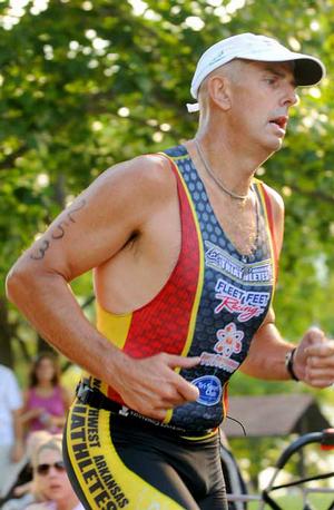 After swimming 500 yards and bicycling 15 miles, John Owen from Rogers began a 5K run on his way to victory in the men's division of the Shark Sprint Triathlon at Horseshoe Bend Park on Beaver Lake on Sunday.