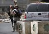 A private contractor acknowledges colleagues flying over in a helicopter as they secure the scene of a roadside bomb attack in this 2005 photo. Iraqi authorities arrested a British contractor on murder charges Sunday in the shooting deaths of a British and an Australian contractor in Baghdad's Green Zone.
