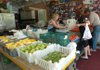 Sue Campbell, left, gives Farmington resident Alice Martin her change as Bobby Campbell, right, arranges tomatoes Tuesday afternoon in the Campbell's vegetable store
in Farmington. The Farmington City Council is beginning discussions on creating a farmers market in Farmington.