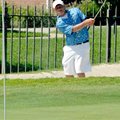 Rogers junior Jake Rylee blasted out of a sand trap at the par-3 8th hole during Monday's golf match...