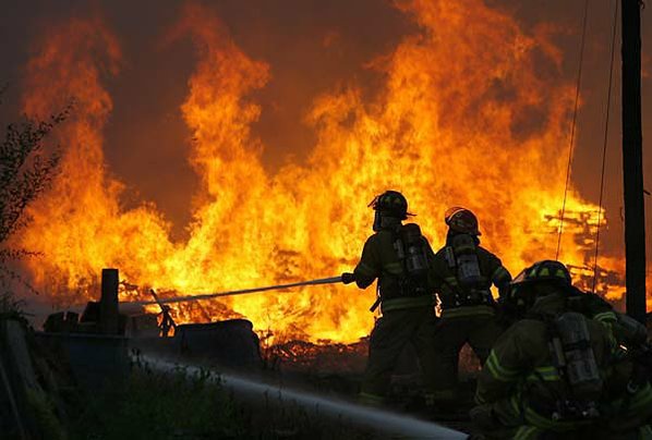Firefighters work to control a ...