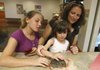 Rabbit raising Olivia Vinson (left), 12, of Van Buren, her cousin Hannah Watson, 5, and aunt Kim Watson both of Mill Valley, Calif., pet a baby rabbit Wednesday at the Janet Huckabee Arkansas River Valley Nature Center in Barling where Kimberly Blackwood is caring for the animal until it is old enough to be released.