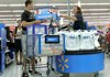 Shoppers move through the check-out line recently at a Wal-Mart in Tallahassee, Fla. The retailer earned $3.44 billion, or 88 cents per share, in the quarter that ended July 31. 