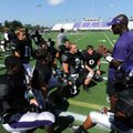 Fayetteville assistant coach Lerinezo Robinson speaks to members of his secondary during the Bulldog...
