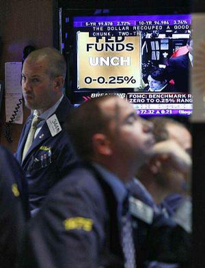 A television screen in a booth on the floor of the New York Stock Exchange on Wednesday shows the Fed interest rate decision. 