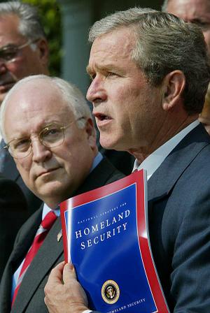 Dick Cheney stands with then-President George W. Bush as Bush outlines national security strategy at the White House in July 2002, a time when Cheney's influence was near its peak.