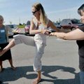 Laura Carlsen, center, passed a can on her foot from between the knees of Crystal Lopez, right, to A...