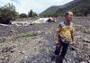 A survivor stands Thursday in front of a destroyed house in Liugui, a village flooded over the weekend by Typhoon Morakot in southern Taiwan.