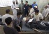 Afghan doctors and workers carry wounded people who were injured by a suicide car bomb explosion at a hospital in Kabul, Afghanistan.