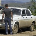 People look at a bullet-riddled car Friday at a checkpoint in Buinaksk, Russia, where four police of...
