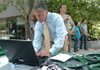 Northwest Arkansas resident Bill Reynolds sends a note to his U.S. senator Monday during the Highway to Health Care RV Tour stop in Fayetteville on the downtown Square. The tour is traveling around the nation to promote health care reform. 