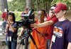 Filmmaking instructor Juli Jackson (second from right) trains Joshua Miller (center) and Austin Robinson on camera operation technique while Grace Huynh (left) steadies the microphone for a scene from Young Heroes: Military Teens Speak Out, a documentary co-produced by the Ozarks Foothills Film Festival and the 4-H program Operation Military Kids.