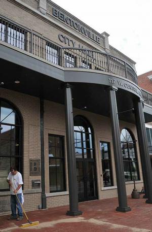 Eddie Bohannan, with Heckathorn Construction Co. Inc. of Fayetteville, swept sand in-between the bricks in front of the Bentonville City Hall on Wednesday. 