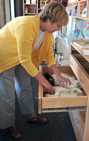 Janelle Redlaczyk, youth and families program coordinator for Crystal Bridges, looked at some of the old toys and clothes at the Massey building on Wednesday. 
