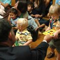 U.S. Rep. John Boozman, left, hands a book to Cade Munter, 1, Thursday at the Northwest Arkansas Ped...