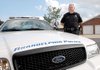 Cpl. Robert Jones with the Arkadelphia Police Department stands near one of the agency's Ford Crown Victoria patrol cars, which will soon be largely replaced with hybrid Toyota Camrys.