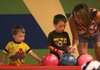 Chire Hodges (right) of Fayetteville helps her nephew Tarren Hodges, 4, choose a ball as Terren's brother
Tristan, 3, looks on Sunday at Fast Lane Entertainment in Rogers. The brothers from Clarksville were visiting family in Northwest Arkansas.