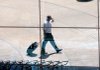 A passenger is reflected in the main terminal windows as he leaves Little Rock National Airport, Adams Field, on Monday afternoon.