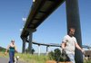 Robert Maunery walks his dog Barkley while Bonnie Guthrie escorts her dog Cash under the Big Dam Bridge in Little Rock during an outing Sunday.