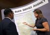 Becky Selle (right), Washington County program technician with Farm Service Agency, discusses the map of the Illinois River watershed Tuesday with Naccaman Williams of the Walton Family Foundation before a news conference at the Embassy Suites in Rogers.
