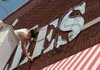 Sign specifications Bryce Jennings with Arc-oma signs of Springdale measures the old Jerzees sign as he prepares to remove and replace it with a new sign for Sunrise Cafe on West Avenue in Fayetteville. The cafe is expected to open in September. 