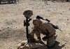 A U.S. Marine pays his respects to a fallen comrade, killed earlier this month in a Taliban ambush, during a memorial service Thursday at a forward operating base in Now Zad in Afghanistan's Helmand province.